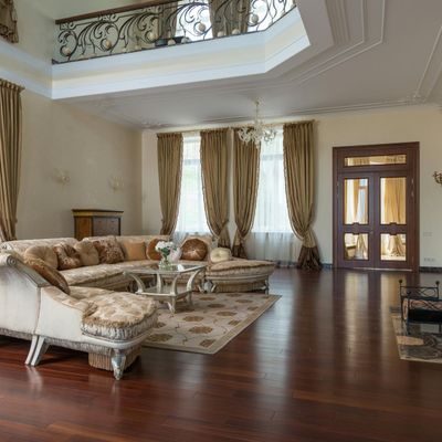 An empty yoga mat on a wooden floor near a large window.